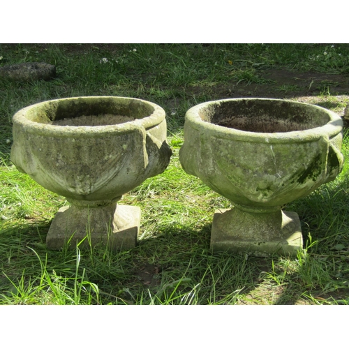 688 - A pair of weathered cast composition stone garden urns, the circular bowls with classical repeating ... 