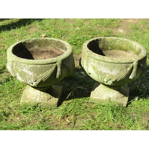 688 - A pair of weathered cast composition stone garden urns, the circular bowls with classical repeating ... 