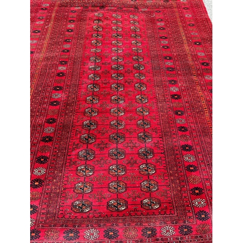 2686 - A large Turkoman carpet with a central panel with three rows of elephant foot guls on a predominatel... 