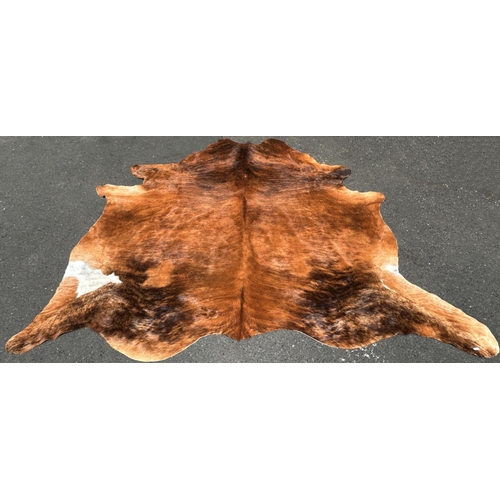 2696 - A cow hide rug/covering, branded R, with one small hole, 220cm x 180cm approx.