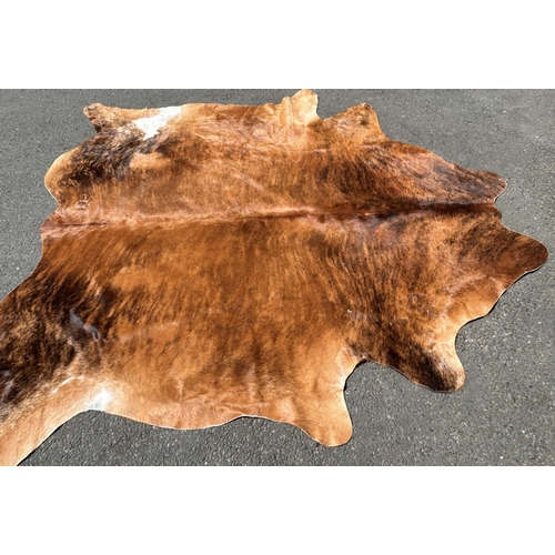 2696 - A cow hide rug/covering, branded R, with one small hole, 220cm x 180cm approx.