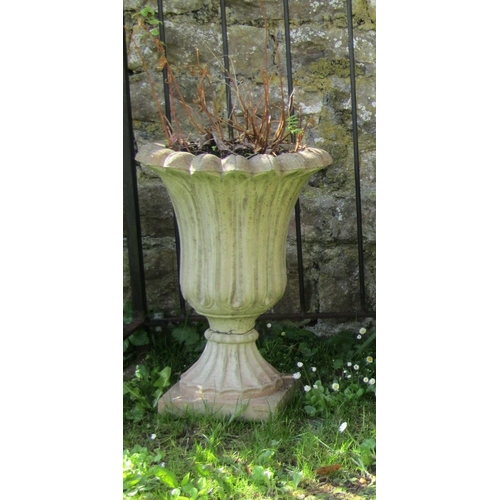 726 - A weathered cast composition stone garden urn with flared egg and dart rim and foliate detail raised... 