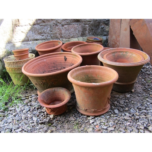 684 - A quantity of weathered terracotta outsized flower pots and planters of varying size and design, the... 