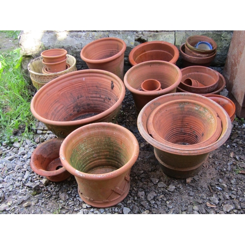 684 - A quantity of weathered terracotta outsized flower pots and planters of varying size and design, the... 