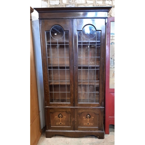 3096 - An Edwardian oak library bookcase enclosed by two leaded light doors over two panelled doors 100 cm ... 