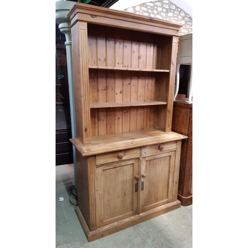 3109 - A pine cottage dresser enclosed by two panelled doors and two drawers with plate rack above, 105 cm ... 