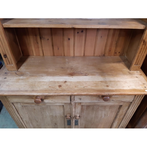 3109 - A pine cottage dresser enclosed by two panelled doors and two drawers with plate rack above, 105 cm ... 