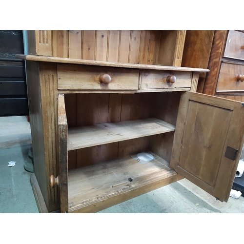 3109 - A pine cottage dresser enclosed by two panelled doors and two drawers with plate rack above, 105 cm ... 