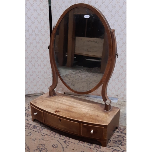 3122 - A Georgian mahogany toilet mirror with oval mirror plate, box base