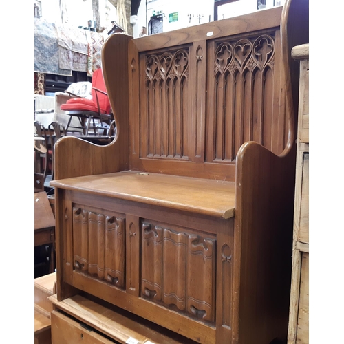 3124 - An old English style box settle with carved and panelled back with ecclesiastical style detail, line... 