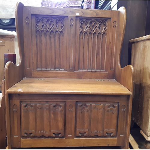 3124 - An old English style box settle with carved and panelled back with ecclesiastical style detail, line... 