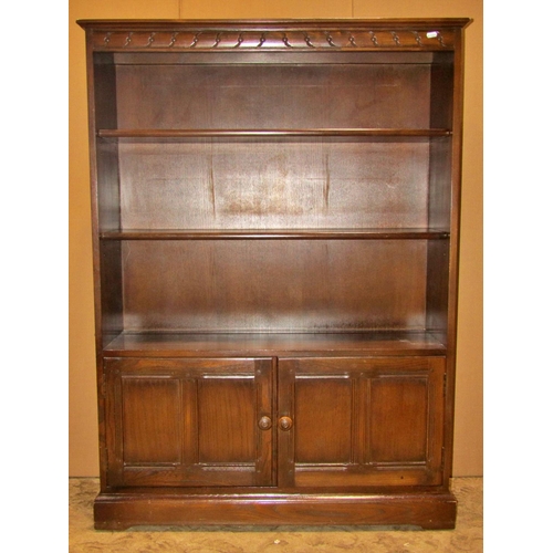 3102 - Ercol dark stained elm floorstanding bookcase, partially enclosed by a pair of moulded panelled door... 