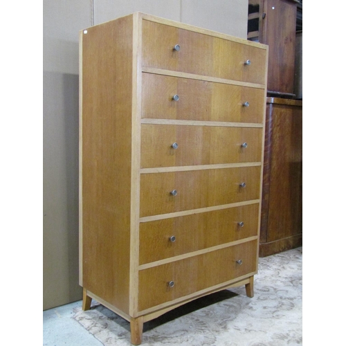 3130 - A mid 20th century oak veneered upright tower of six drawers on swept supports 85 cm wide