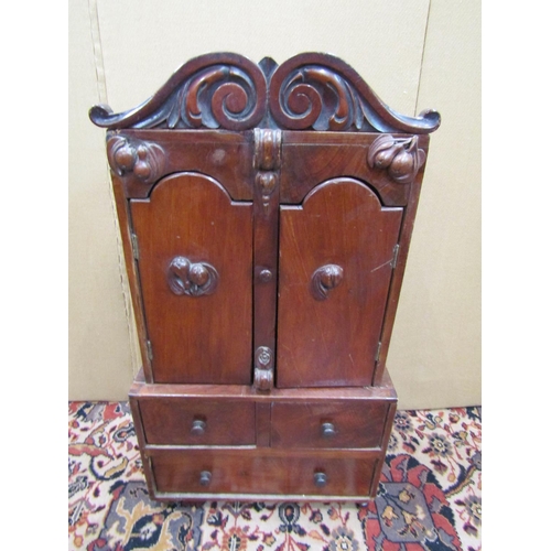 3517 - A miniature 19th century mahogany cabinet, the lower section enclosed by one long and two short draw... 