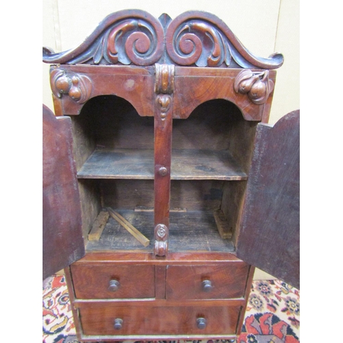 3517 - A miniature 19th century mahogany cabinet, the lower section enclosed by one long and two short draw... 