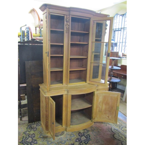 3550 - A 19th century stripped and waxed pine three door library bookcase, the lower section with bowfronte... 