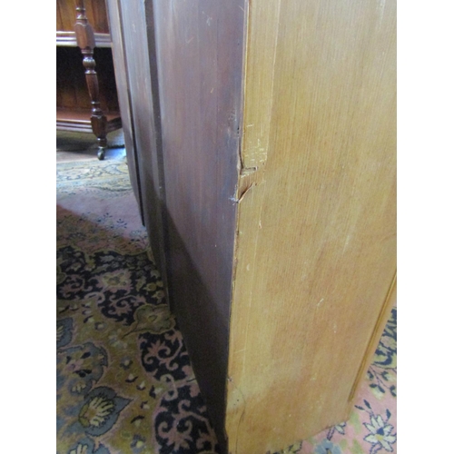 3550 - A 19th century stripped and waxed pine three door library bookcase, the lower section with bowfronte... 