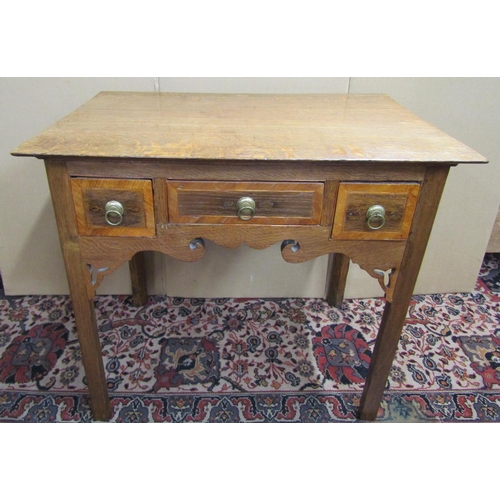 3551 - A Georgian oak cottage lowboy fitted with three frieze drawers within a shaped apron on square mould... 