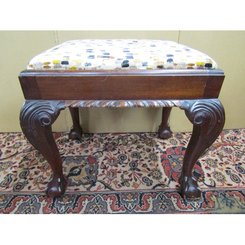 3587 - An Edwardian centre stool with upholstered top raised on shaped supports with acanthus knees and cla... 