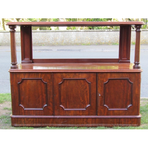 3588 - A Victorian mahogany buffet, the lower section enclosed by three panelled doors with open centre, th... 