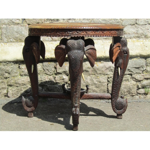 3597 - An Indian hardwood occasional table of circular form with repeating geometric detail raised on four ... 