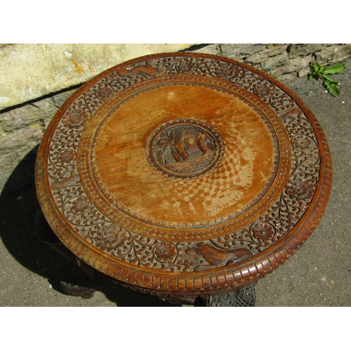 3597 - An Indian hardwood occasional table of circular form with repeating geometric detail raised on four ... 