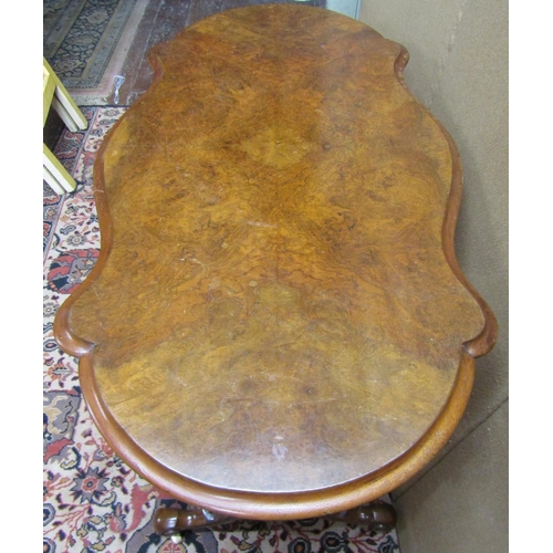 3601 - A Victorian walnut and figured walnut occasional table with shaped outline, raised on a stretcher ba... 