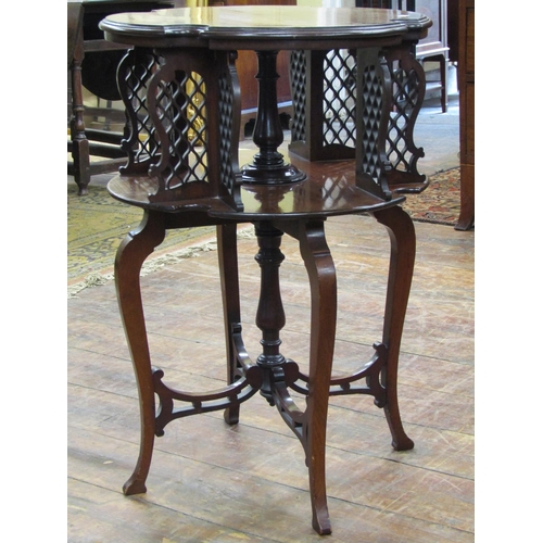 3609 - An Edwardian mahogany revolving occasional table on two tiers with carved and pierced dividers raise... 