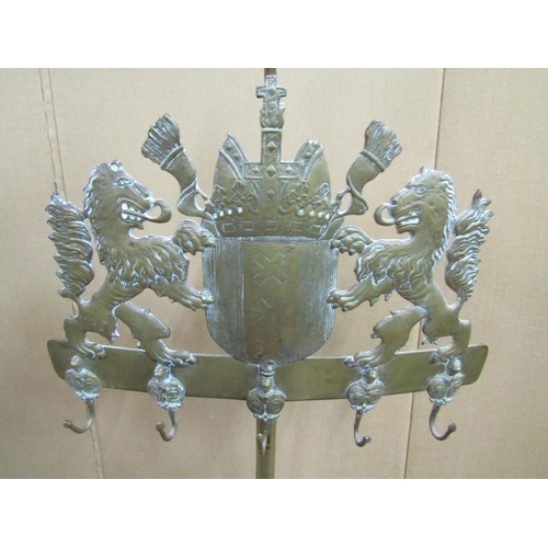 3621 - A cast brass hearth side companion stand on rope twist borders, the armorial panel flanked by two li... 