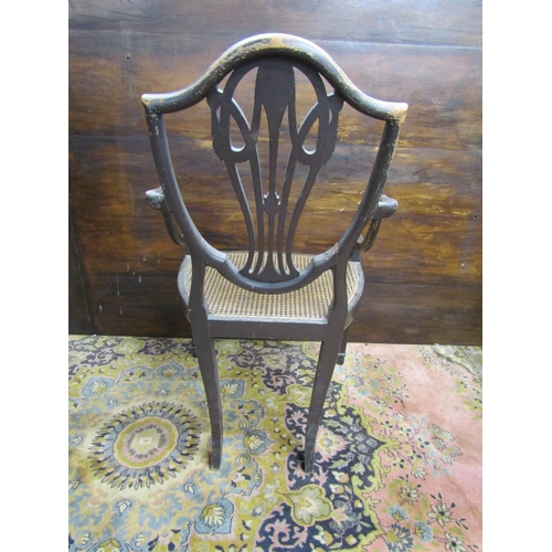 3516 - A regency shield back elbow chair, with cane panelled seat, raised on square tapered legs, with over... 