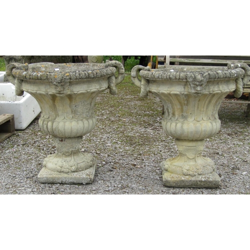 175A - A pair of large weathered cast composition stone campana shape garden urns with fixed ring and loop ... 