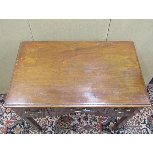 3552 - A Georgian mahogany lowboy fitted with three drawers to a central kneehole, on square cut supports