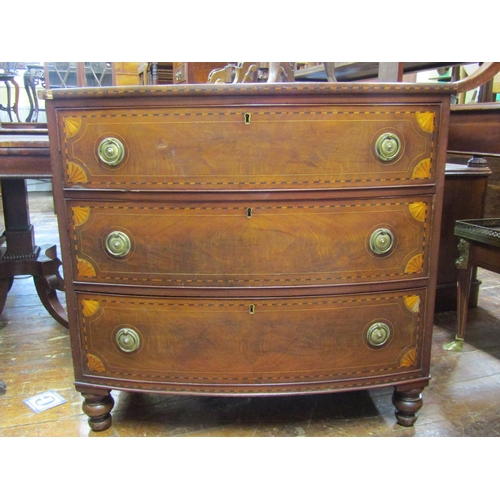 3598 - A Georgian mahogany bow fronted chest of three long drawers with pronounced inlaid detail with chequ... 