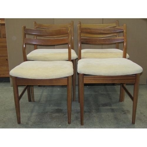 3083 - A set of four mid century dining chairs with upholstered seats on turned supports