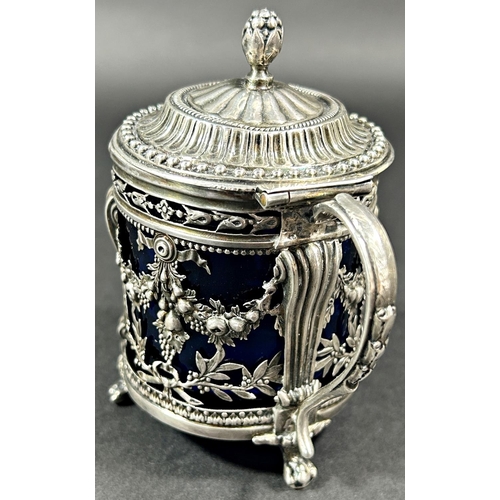 1193 - A Dutch mid 19th century silver mustard pot with blue glass liner, decorated with cherubs and fruit ... 