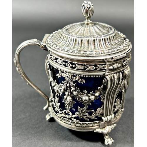 1193 - A Dutch mid 19th century silver mustard pot with blue glass liner, decorated with cherubs and fruit ... 