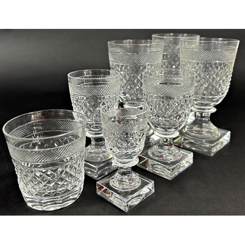 1128 - A suite of early 20th century square cut glass ware, consisting of eight wine glasses, eight tumbler... 