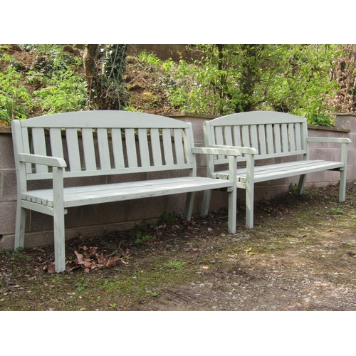 2071 - A pair of light green painted soft wood three seat garden benches with slatted seats and backs benea... 