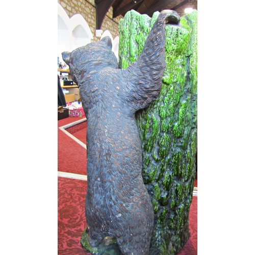 1089 - A Bretbyware stick stand modelled as a tree trunk bear cub, naturalistic painted finish