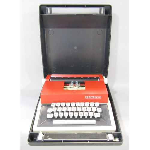 1475 - A 1970’s red and cream plastic Petite International de luxe typewriter, in a hard plastic grey carry... 