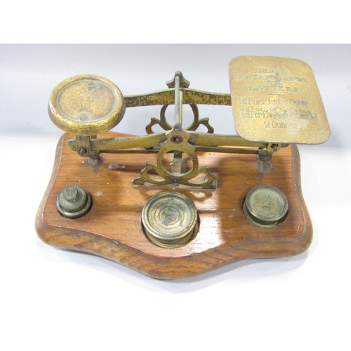 1477 - A set of 19th century brass postal scale on an oak stand, with some odd weights, together with a    ... 