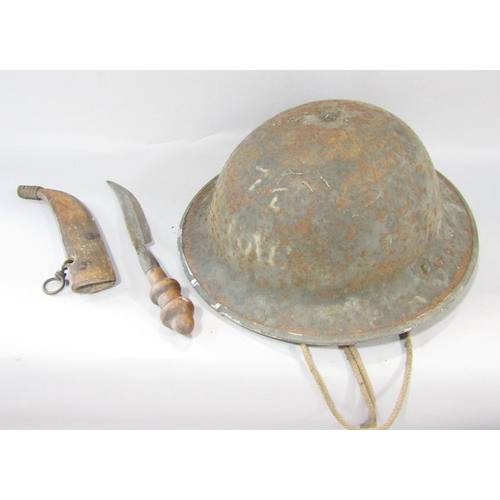 1487 - A rusty military tin helmet with original head padding and chin strap and a crude curved dagger in a... 