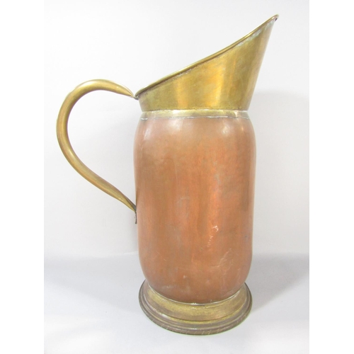 1508 - A 19th century brass and copper pitcher with a brass loop handle, 50cm high.