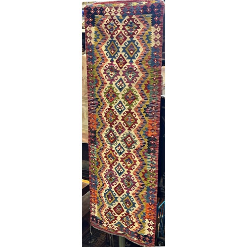 1588 - A Chobi Kilim runner with a repeating multi coloured geometric pattern, 254cm x84cm approx.