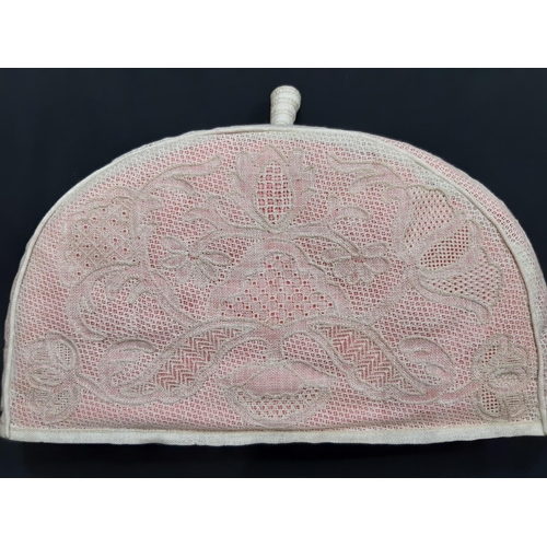 1558 - Exhibition lacework pieces; a handmade tea cosy (1960's) in counted thread lacework with pink lining... 