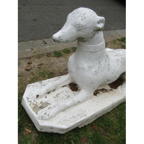 2029 - A painted cast composition stone garden/pier ornament in the form of a recumbent greyhound/whippet s... 