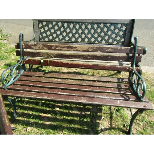 2044 - A two seat garden bench with weathered wooden slatted seat, cast lattice panelled back and scrolled ... 