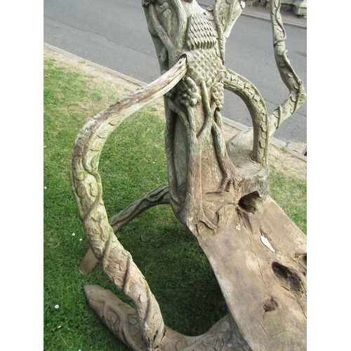 2066 - A large weathered rustic sculptural tree root chair with carved trailing vine, tree and bird detail,... 