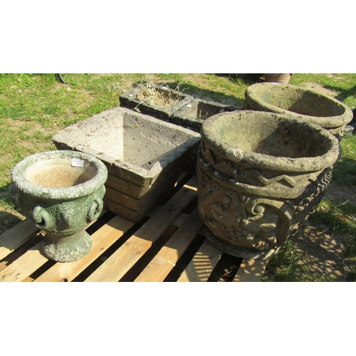 2073 - A pair of weathered cast composition stone circular garden urns with repeating C scroll geometric an... 