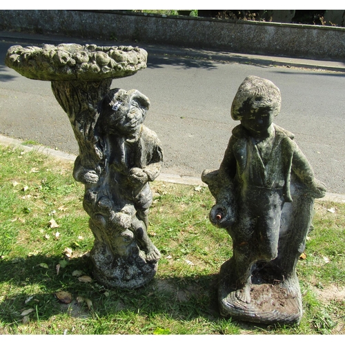 2074 - A weathered cast composition stone two sectional bird bath, the pedestal in the form of a man beside... 